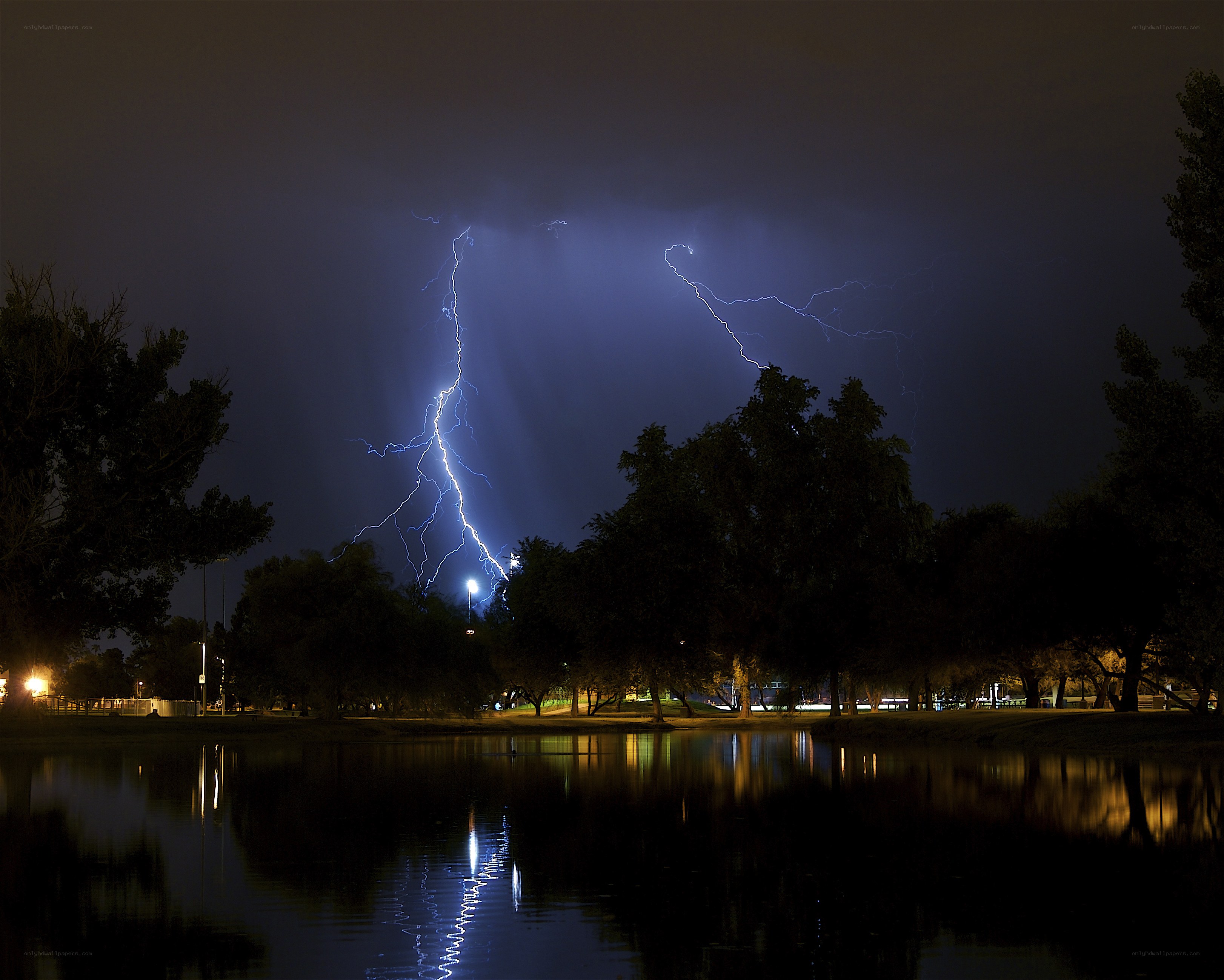 Lightning over a lake at night