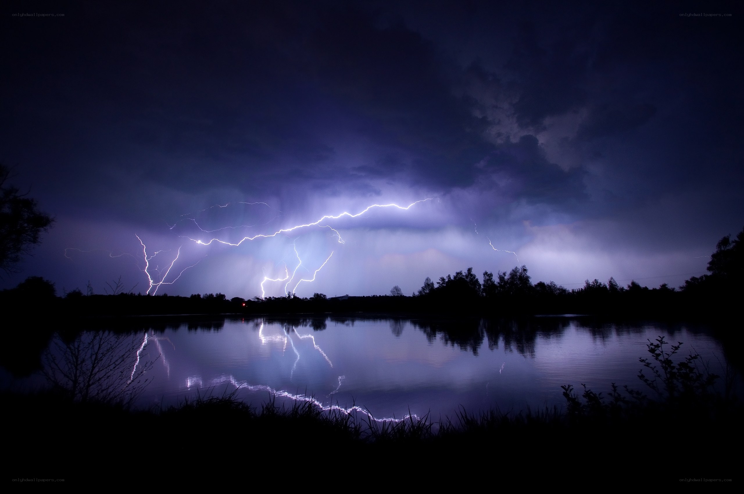 Lightning over a lake at night