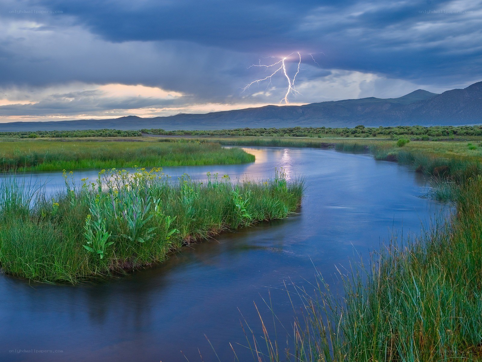Lightning over a river at dusk