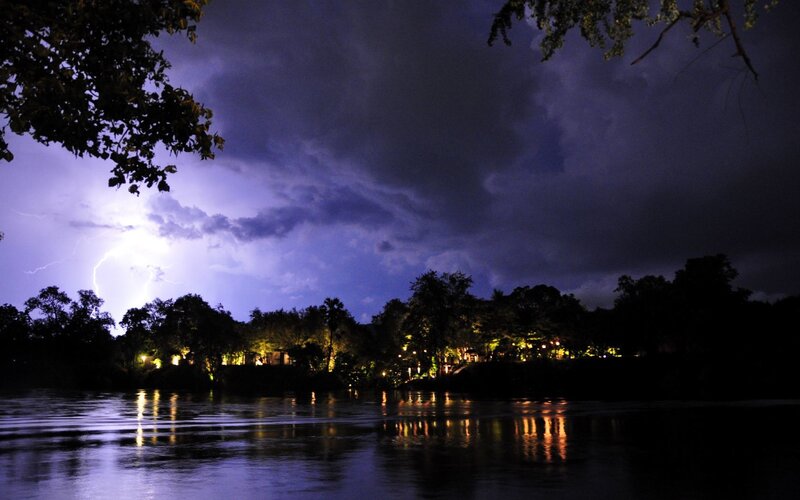 Lightning over a river at night