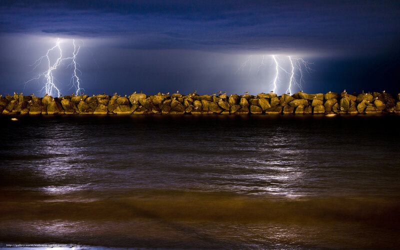 Lightning over a rocky jetty