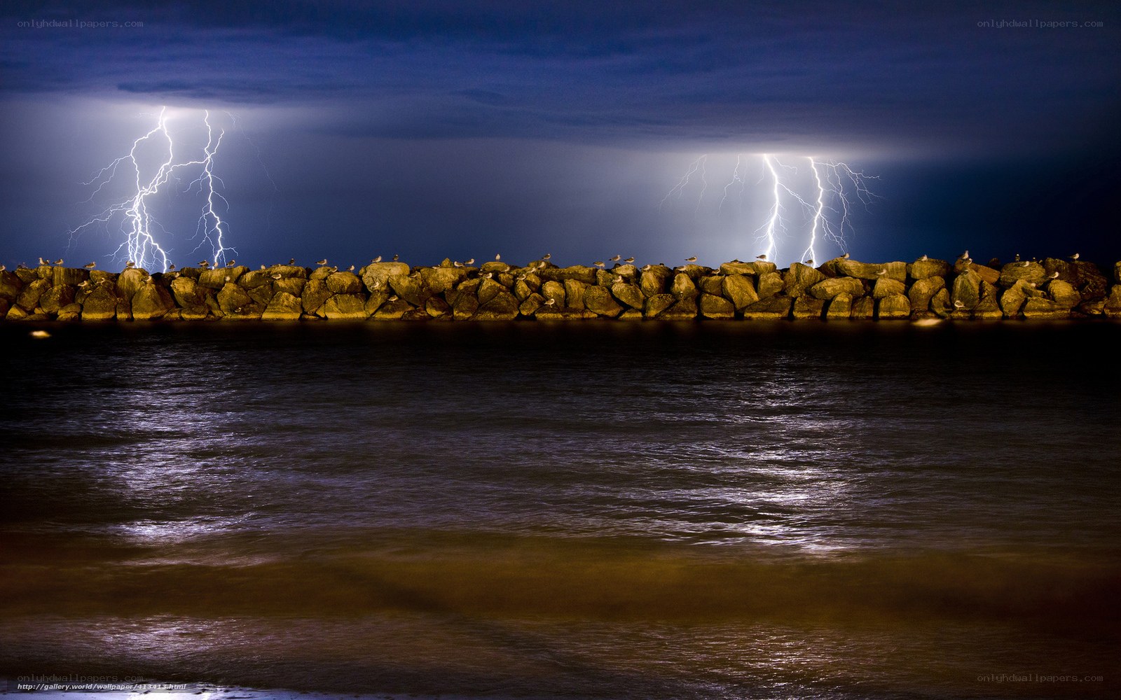Lightning over a rocky jetty