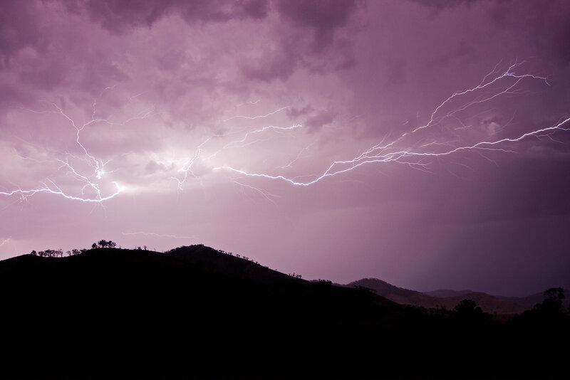 Lightning over hills at dusk