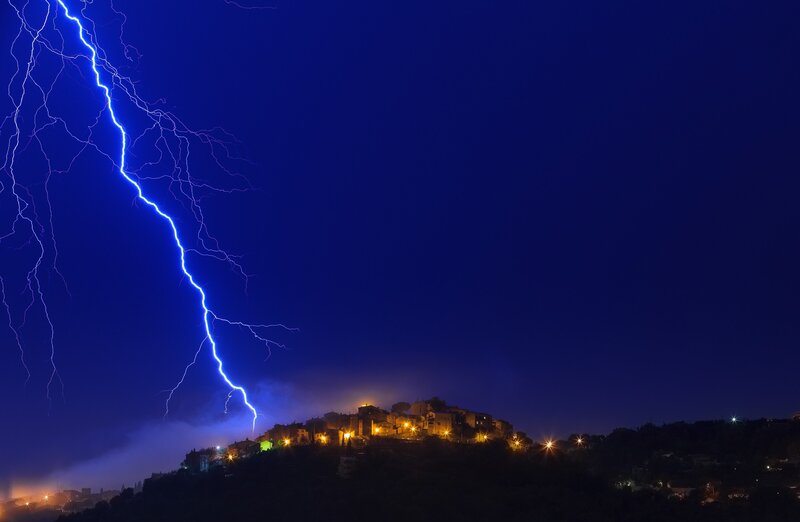 Lightning over hilltop village