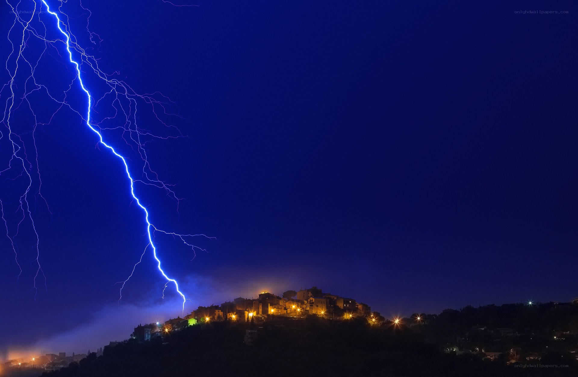 Lightning over hilltop village