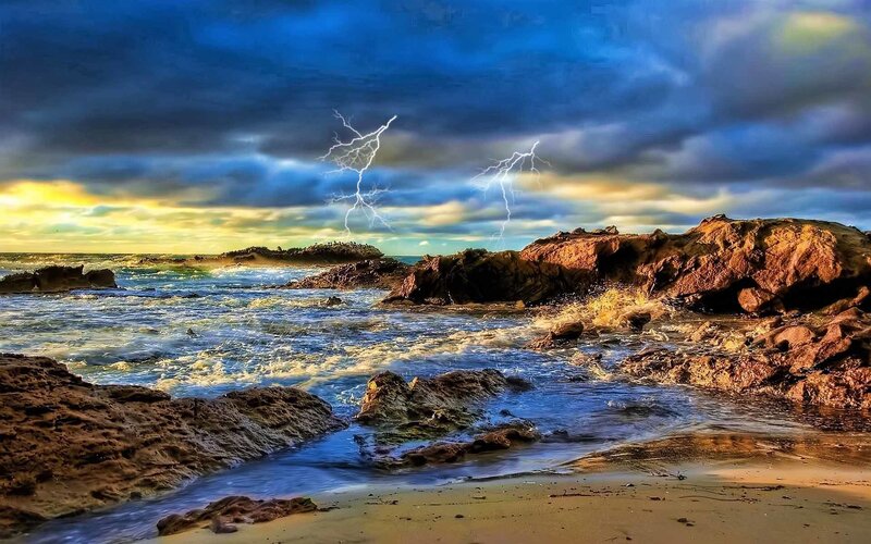 Lightning over rocky coastline