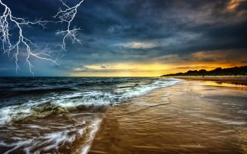 Lightning over the beach at sunset