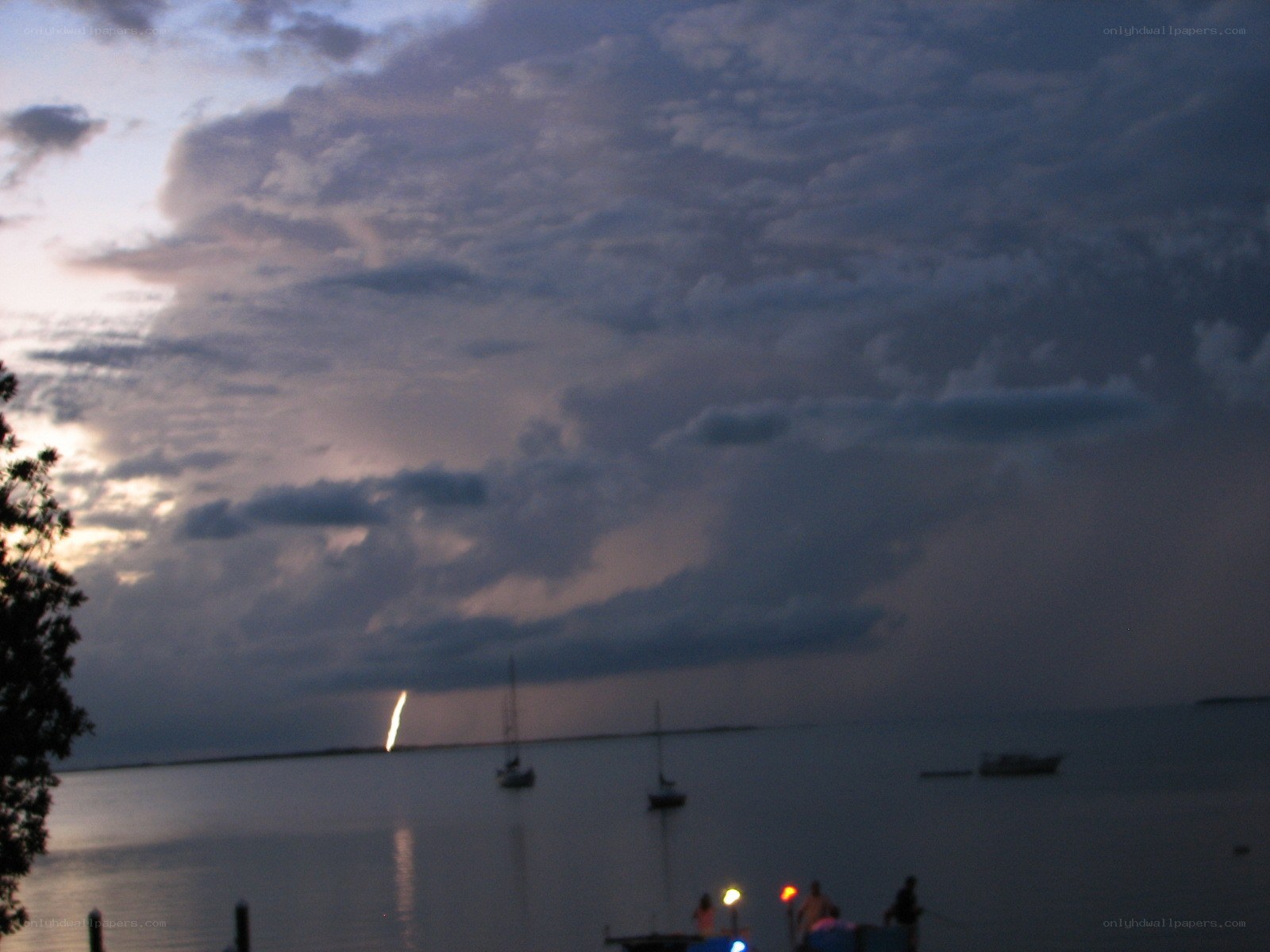 Lightning over the water at dusk