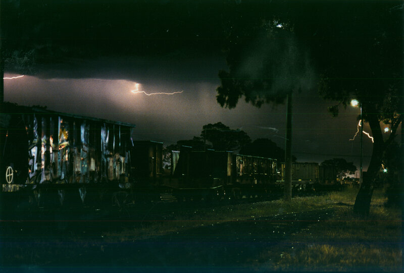 Lightning over train cars at night