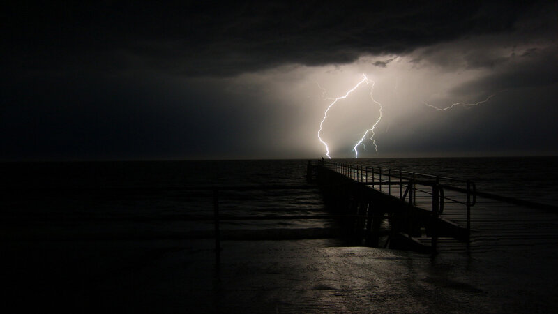 Lightning storm over ocean pier