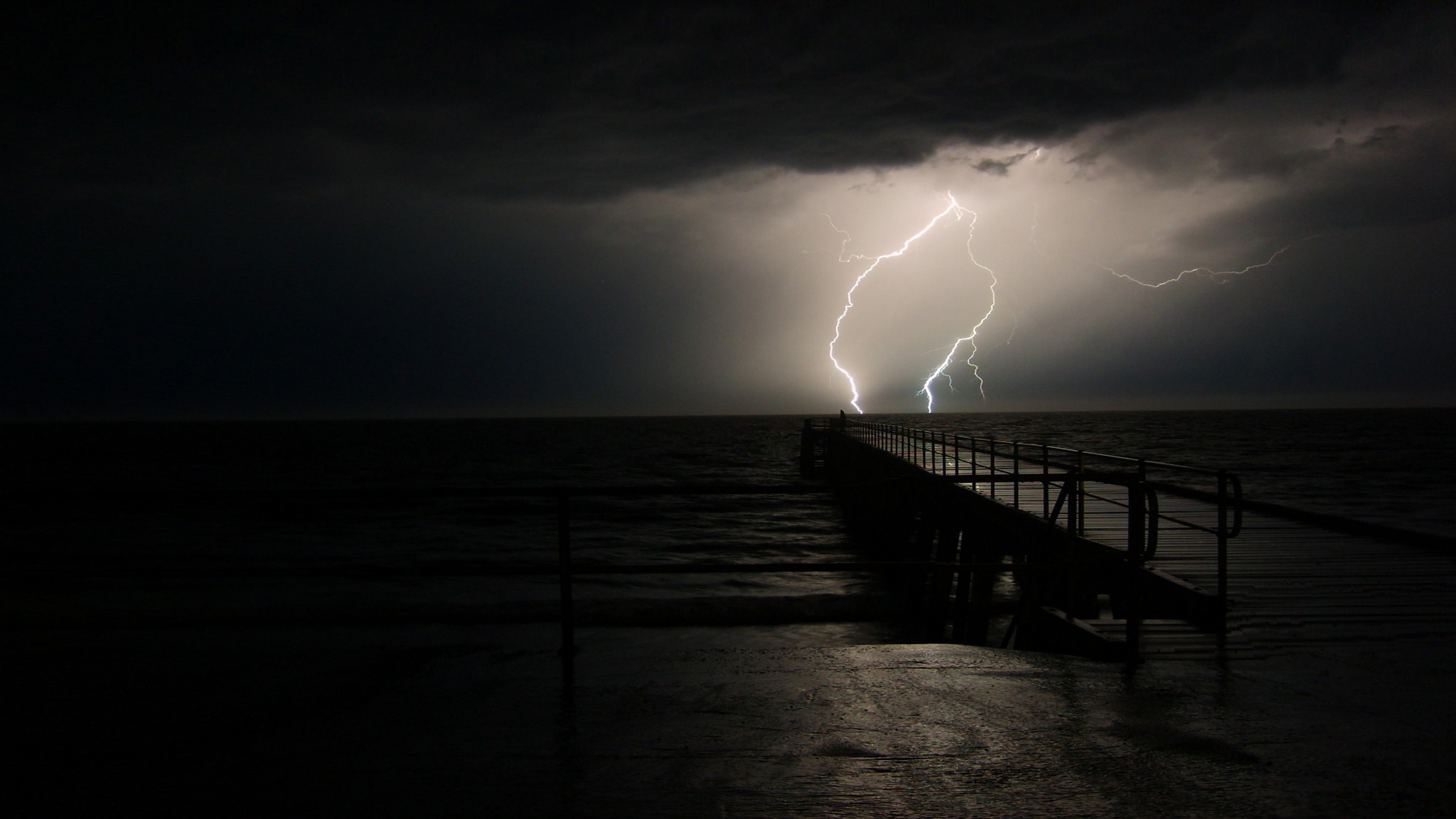 Lightning storm over ocean pier