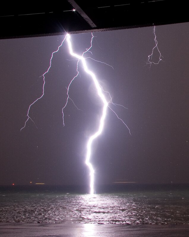 Lightning strikes ocean at night