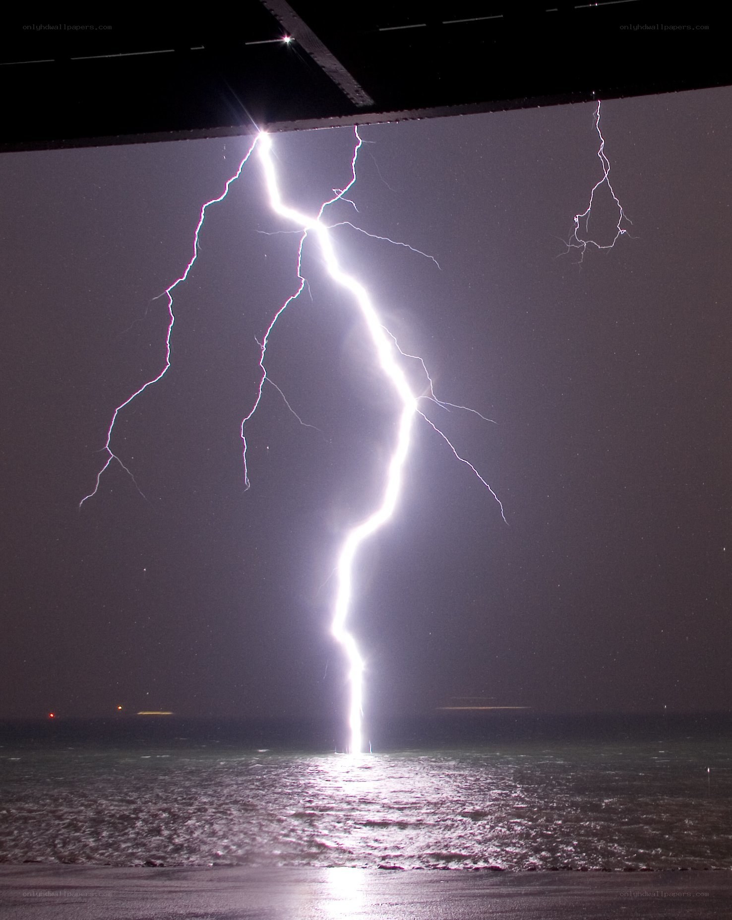 Lightning strikes ocean at night