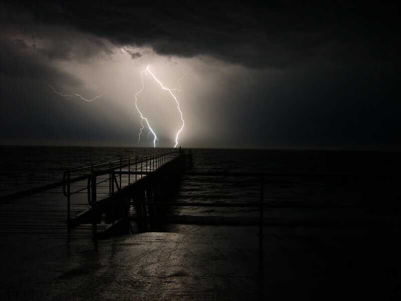 Lightning strikes over a pier