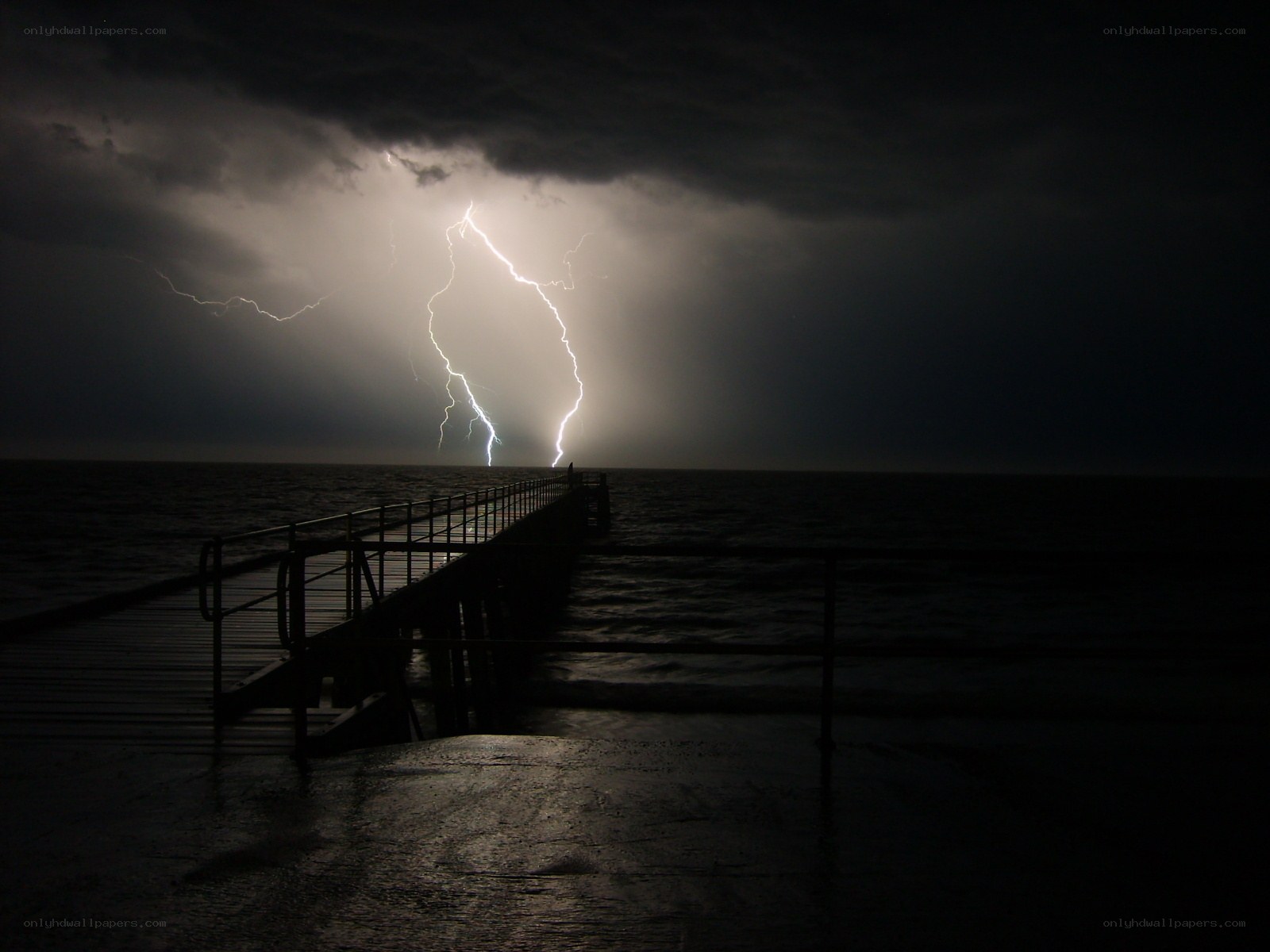 Lightning strikes over a pier