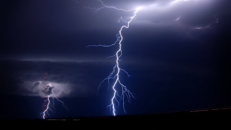 Lightning strikes over a tower