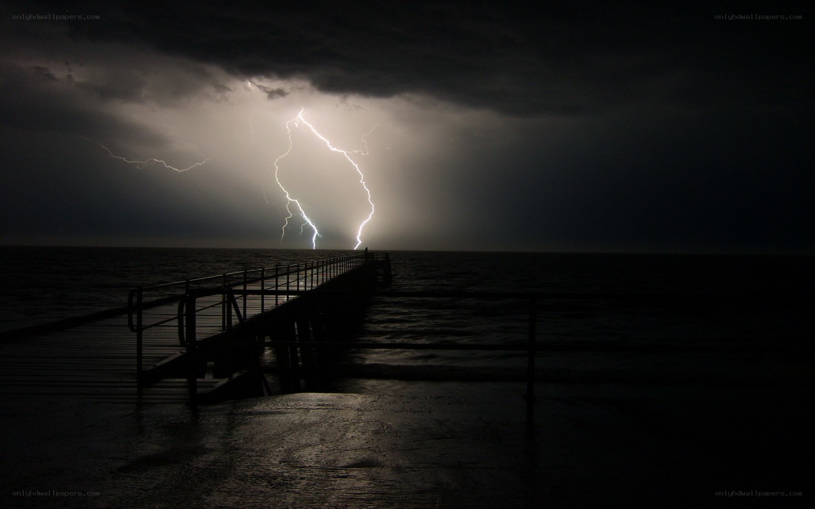 Lightning strikes over ocean pier