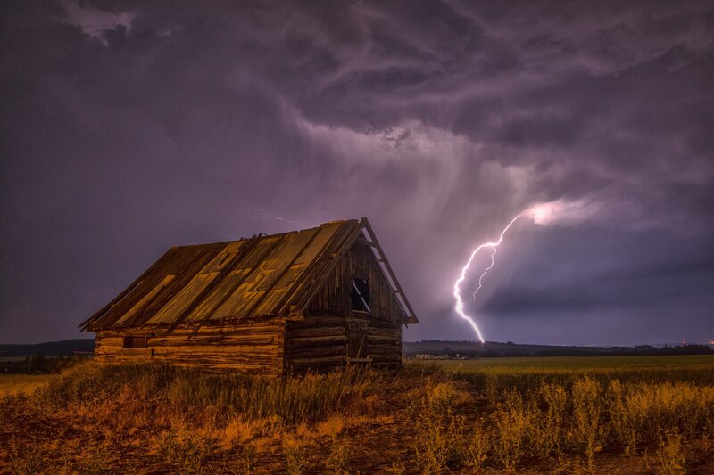 Lightning strikes over old barn