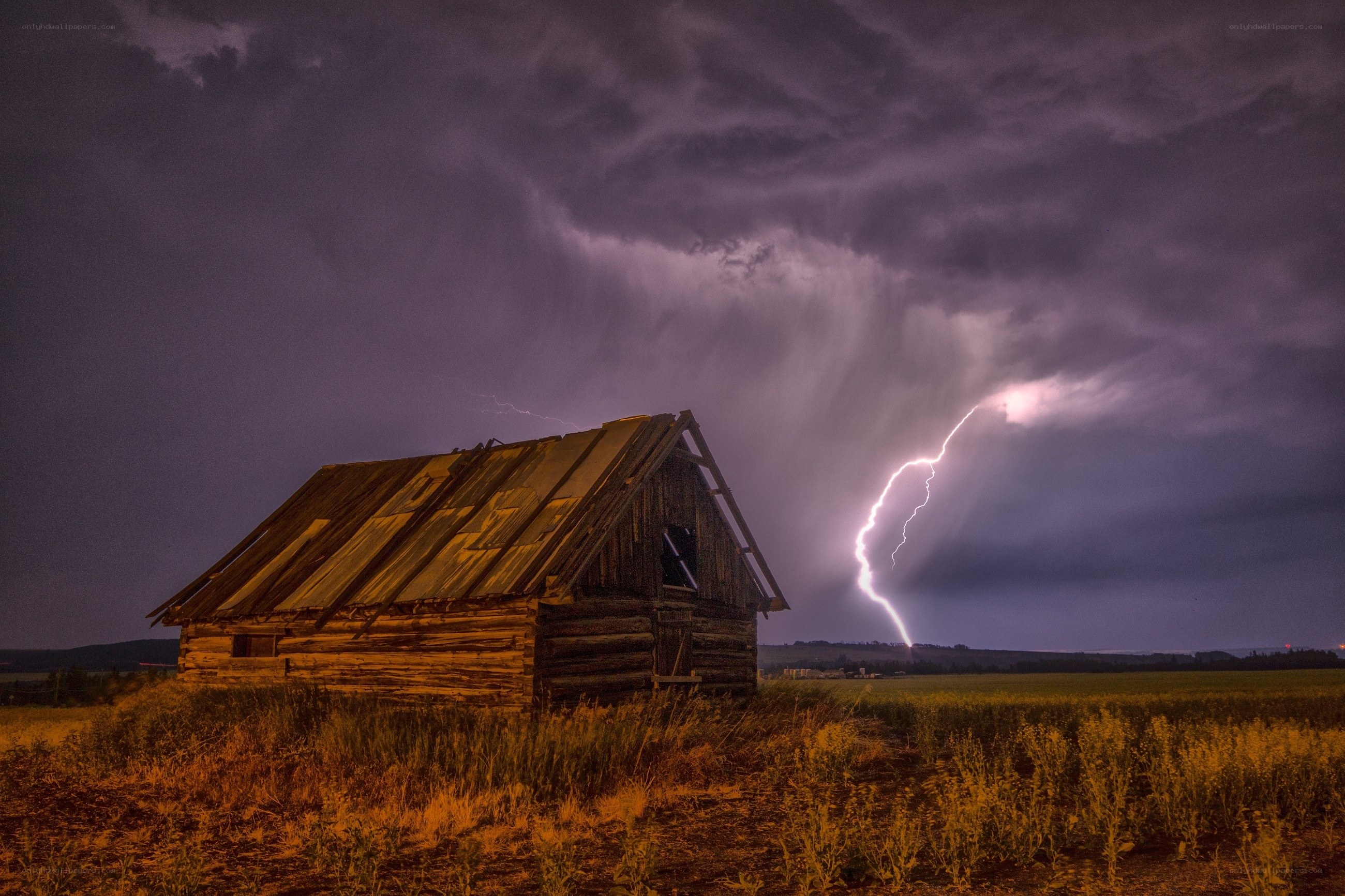 Lightning strikes over old barn