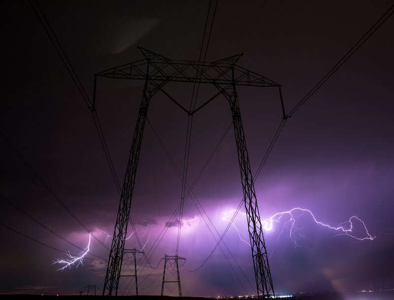 Lightning strikes over power lines