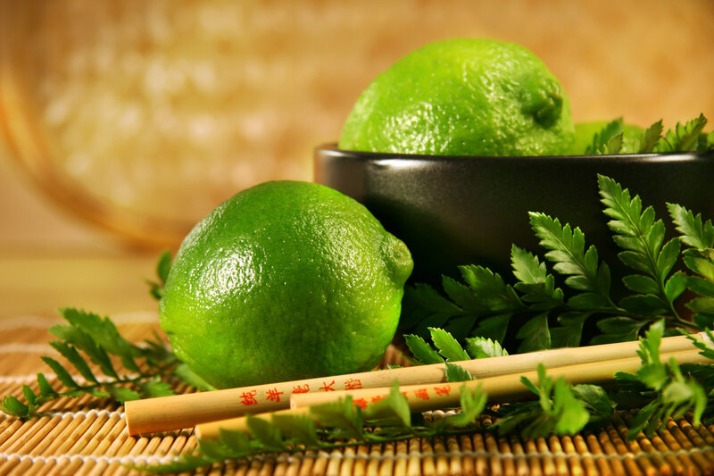 Limes with chopsticks on bamboo mat