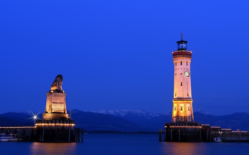 Lion statue and lighthouse at dusk