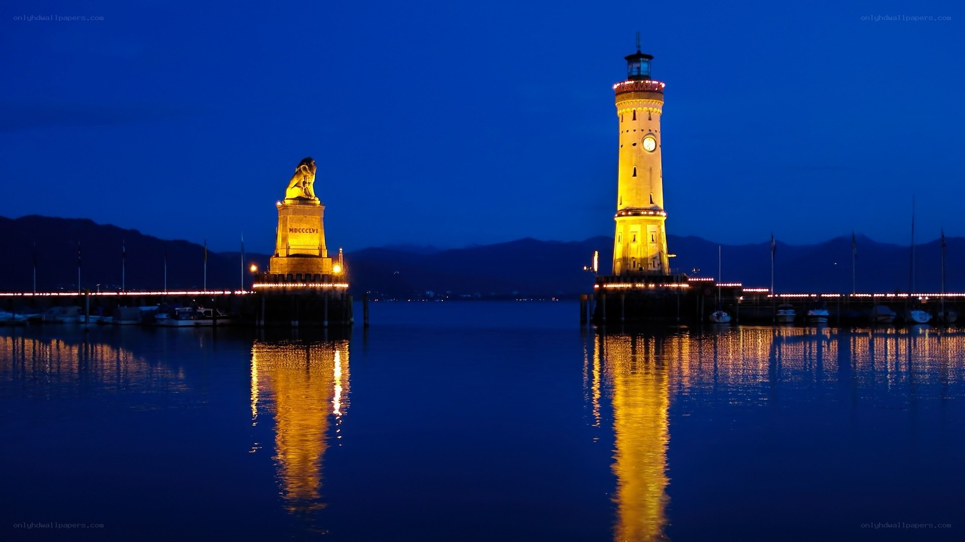 Lion statue and lighthouse at night