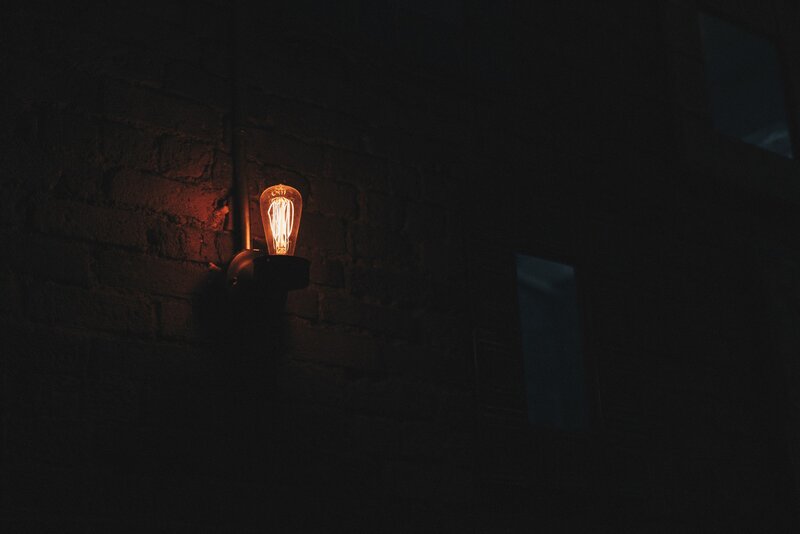 Lit Bulb on Brick Wall