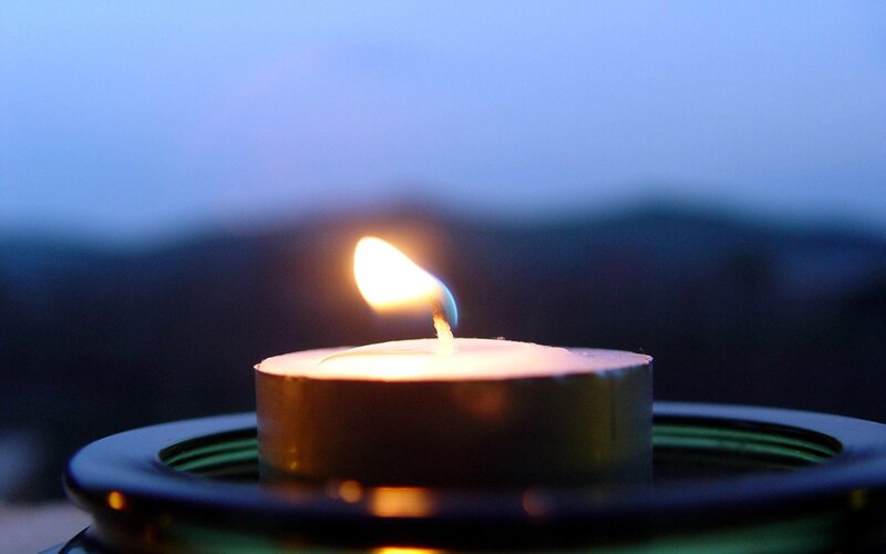 lit candle at dusk