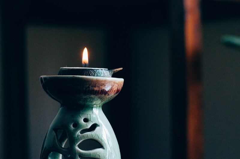 lit candle in ceramic holder