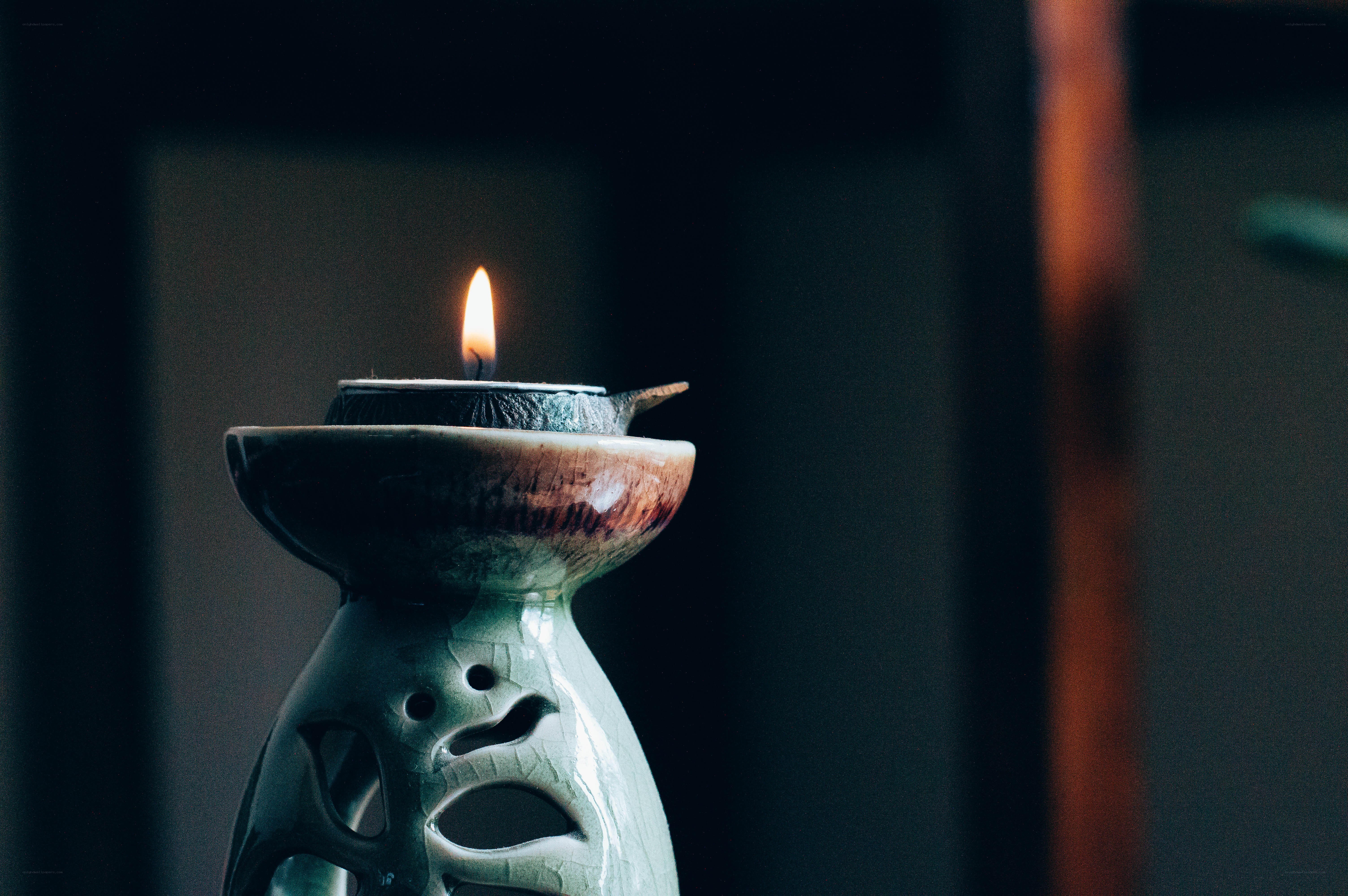 lit candle in ceramic holder