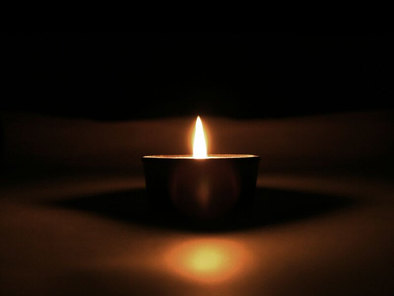 Lit Candle in Dark — Black