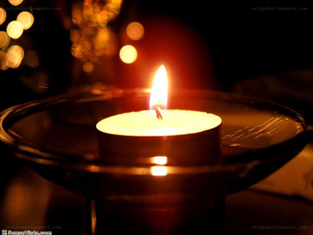 lit candle in dark room
