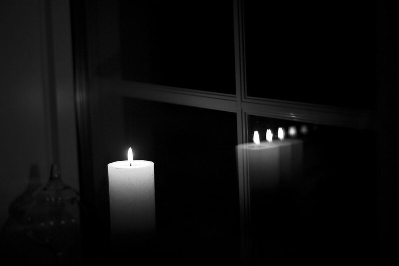 Lit Candle in Dark Room — Black
