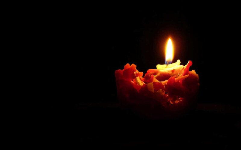 lit candle in darkness