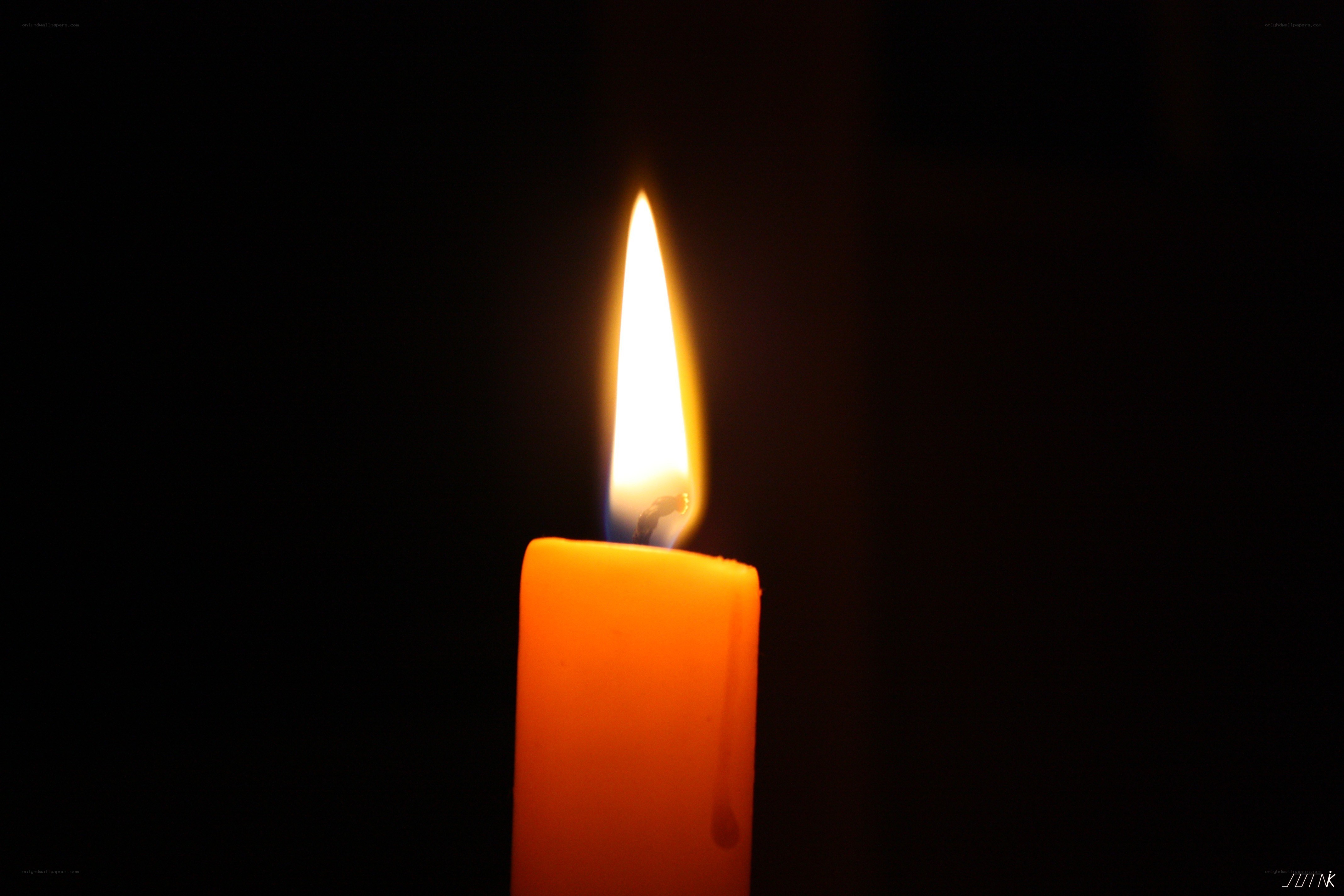 lit candle in darkness