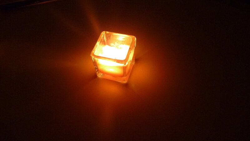 lit candle in glass holder