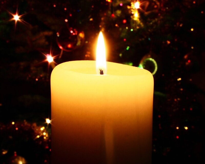 lit candle near christmas tree