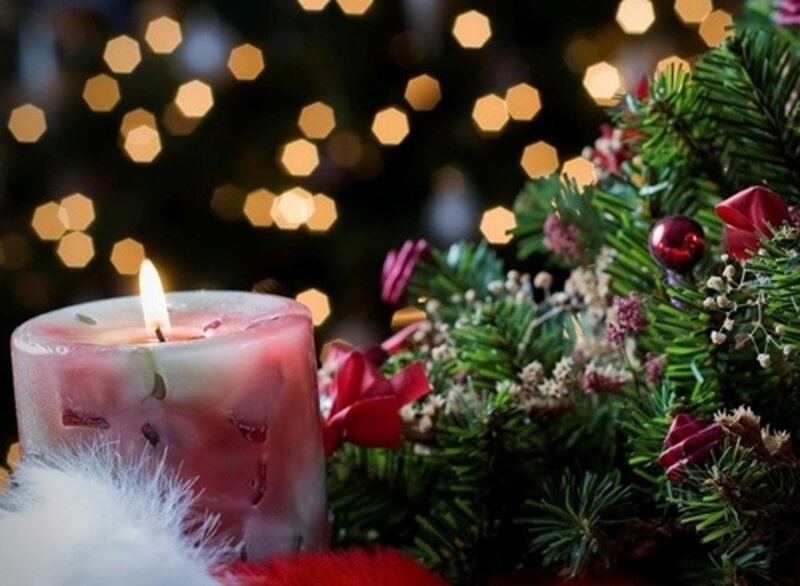 Lit Candle Near Pine Branches