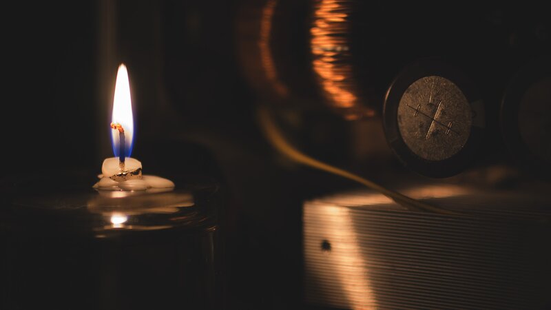Lit Candle on Dark Surface