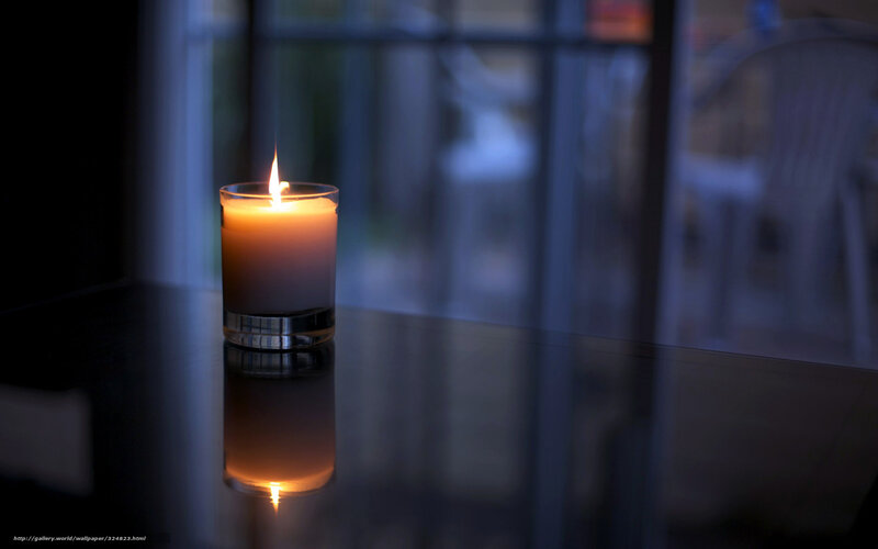 lit candle on dark table