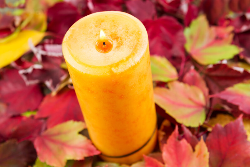 Lit Candle on Leaves