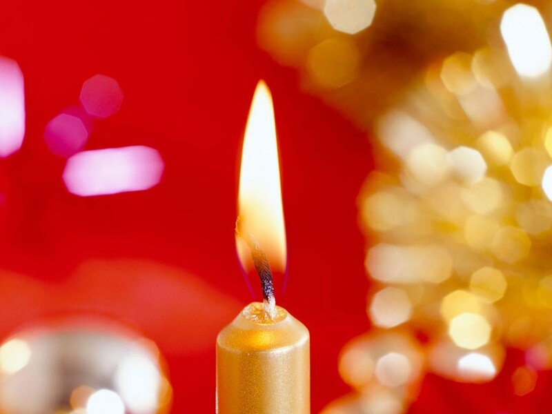 Lit Candle on Red Background