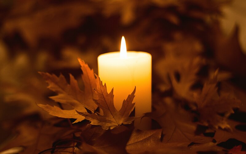 Lit Candle with Autumn Leaves
