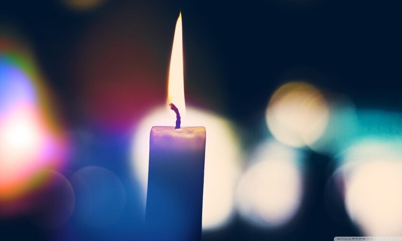 lit candle with colorful bokeh