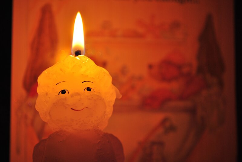 lit candle with smiling face