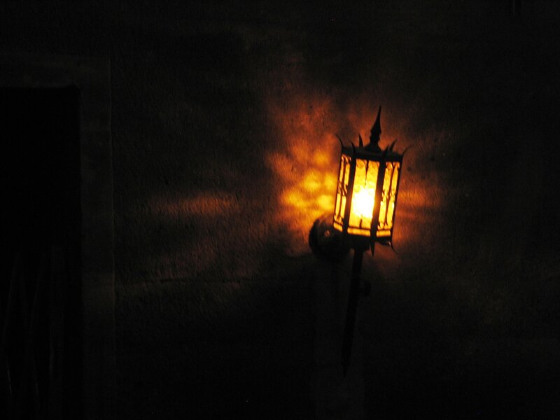 lit lantern on dark wall
