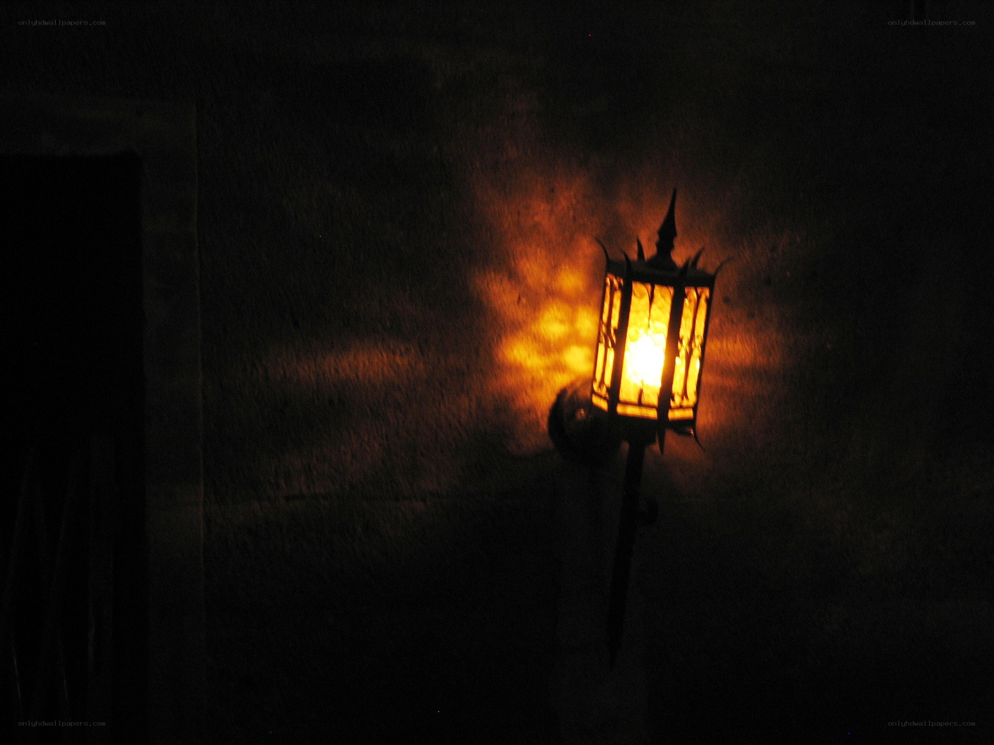 lit lantern on dark wall