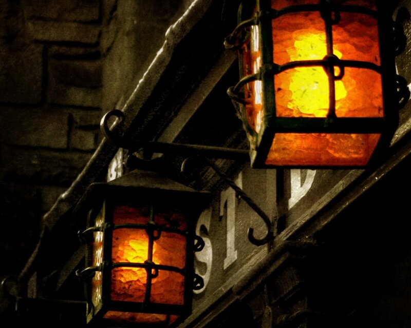 lit lanterns on stone wall