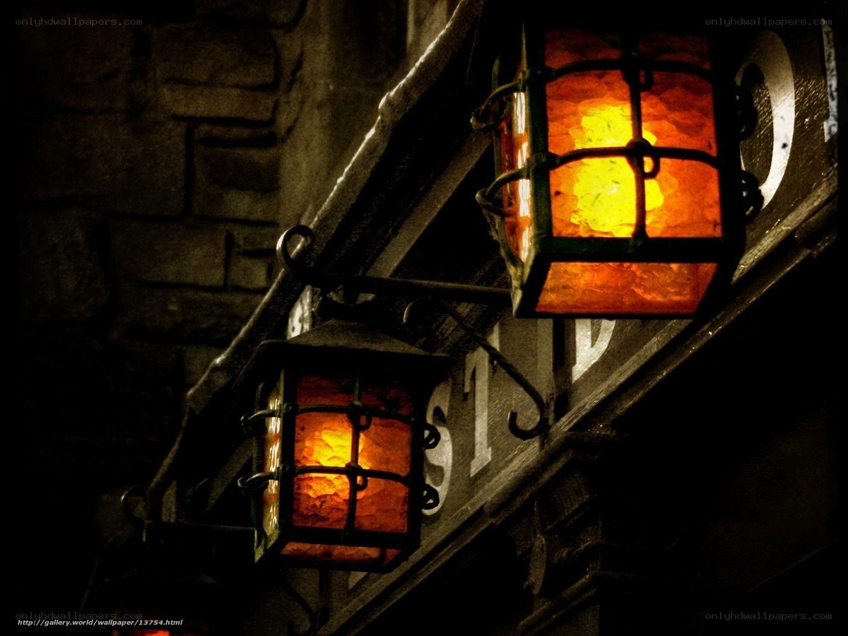 lit lanterns on stone wall